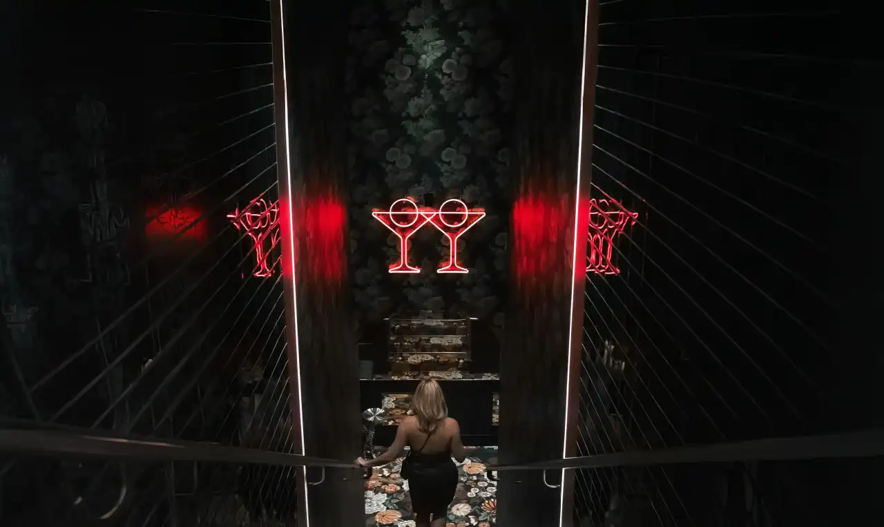 The neon martini glasses at the Tell Your Friends entrance