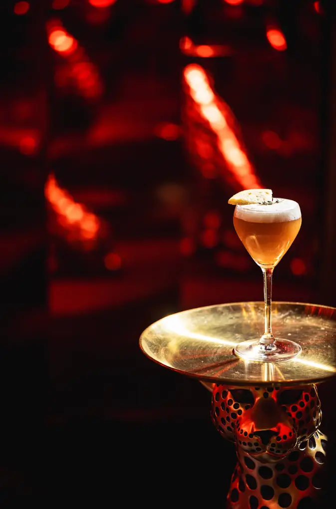 A cocktail served on a gold leopard stand
