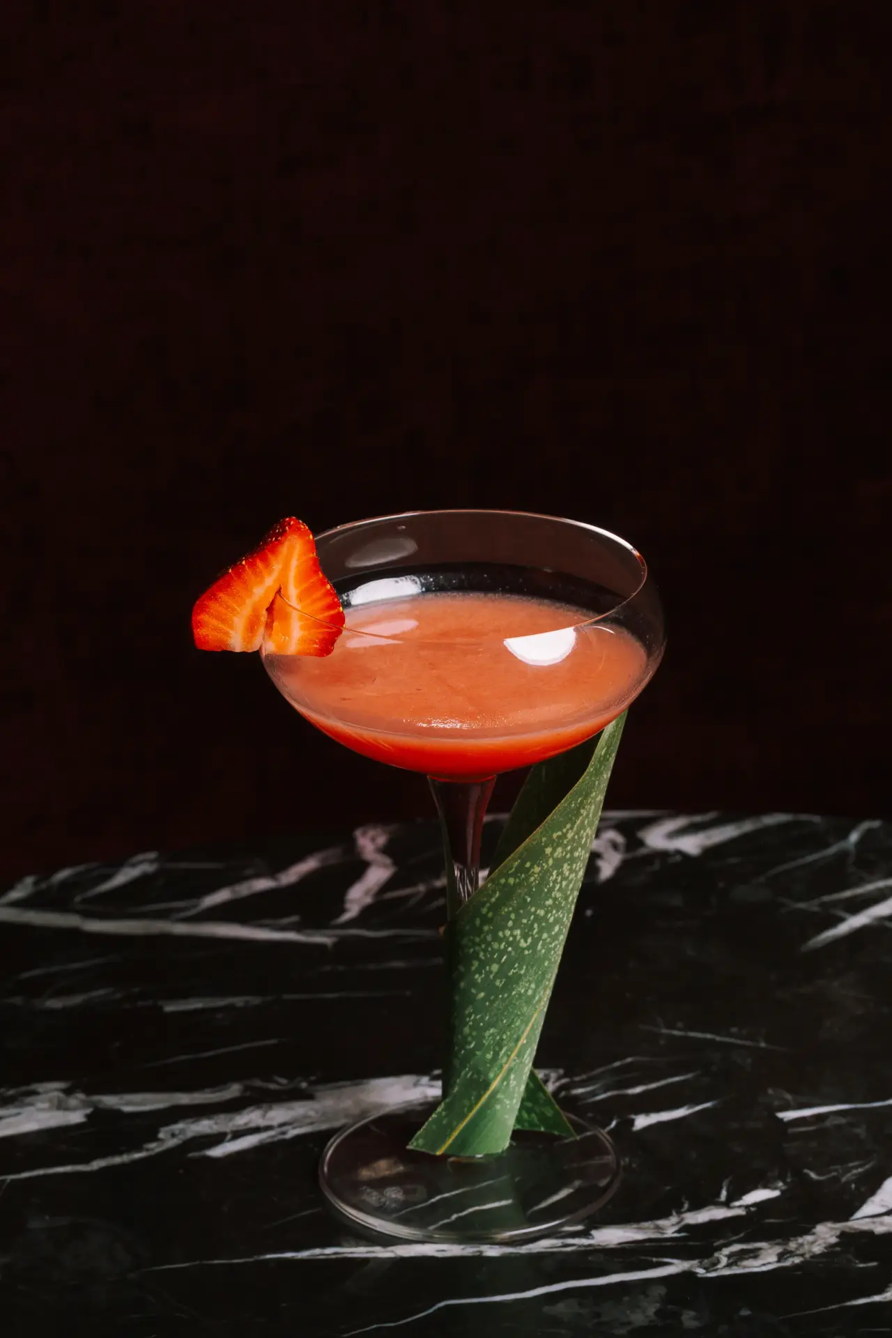 A strawberry martini on black marble